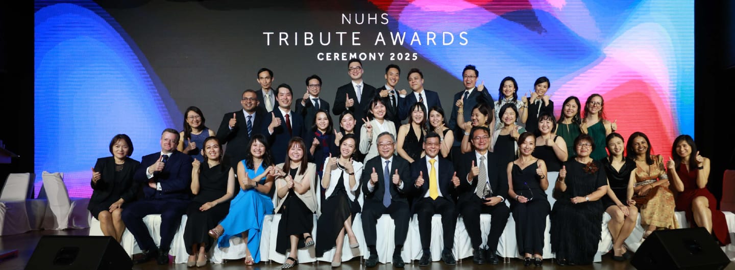 Group of people at NUHS Tribute Awards Ceremony 2025, many giving thumbs up.